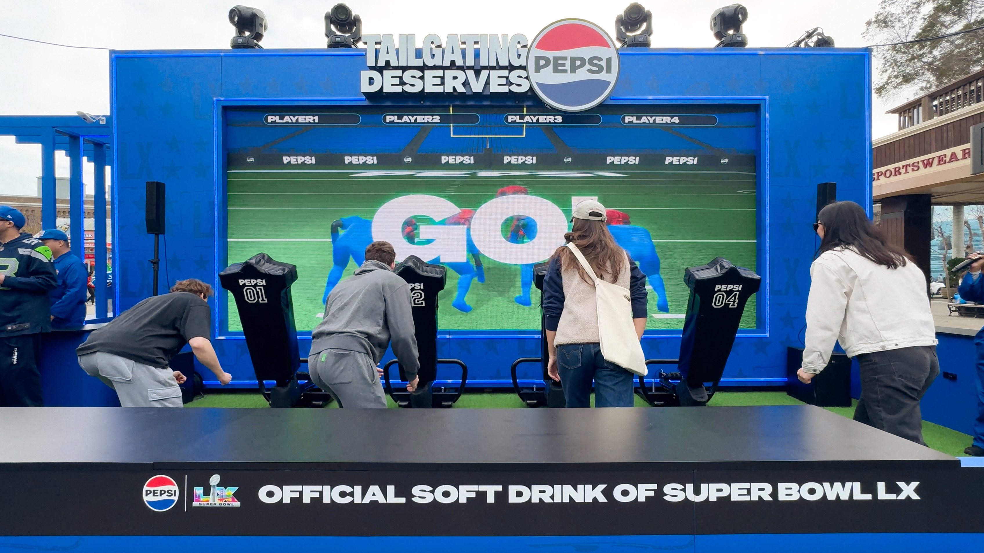 Pepsi interactive football game installation at Super Bowl LX brand activation, participants playing